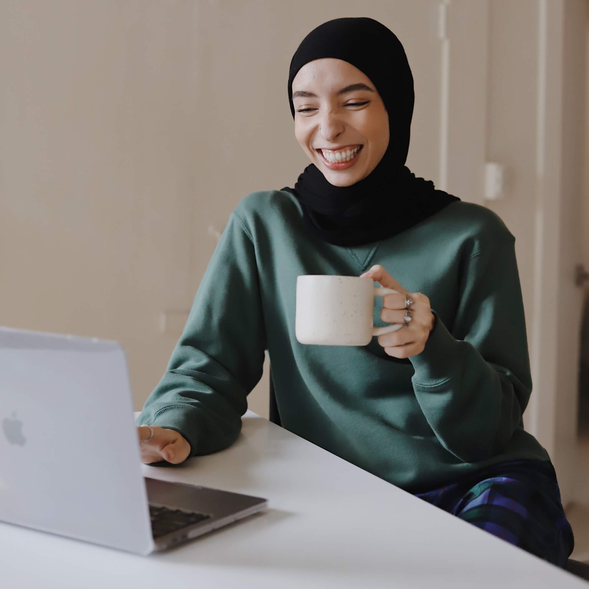 A NurseRecruit attendee smiling at a laptop during a Virtual Career Fair